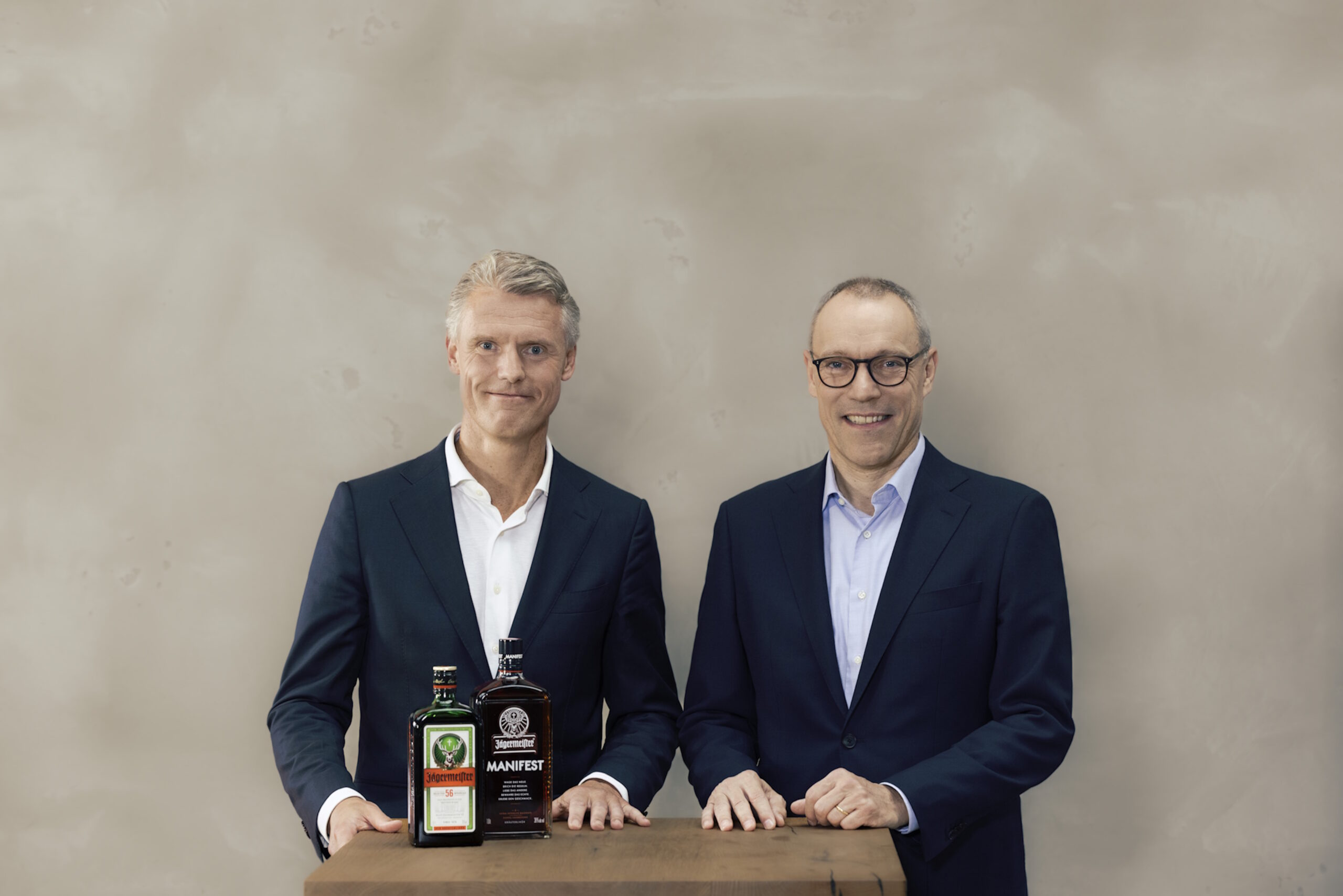 Bernt Kodden und Denis Schrey hinter einem Tisch mit Jägermeister Original und Jägermeister Manifest Flasche
