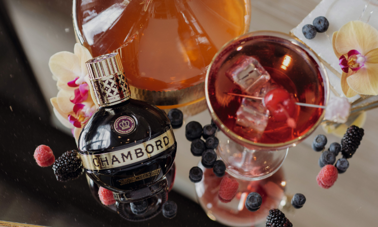 Ein Flasche Chambord auf einem dekorierten Tisch und Cocktailglas