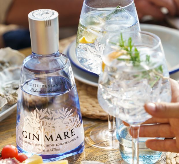 Eine Flasche Gin Mare und davor ein volles Glas