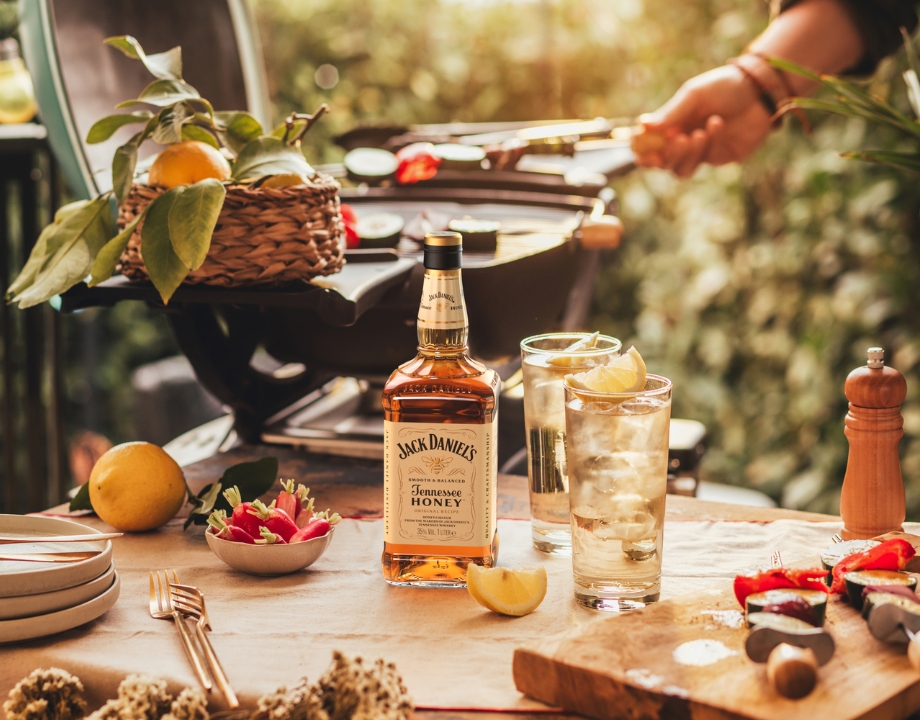 Picknick-Tisch mit Jack Daniel’s Honey und frischem Gemüse.