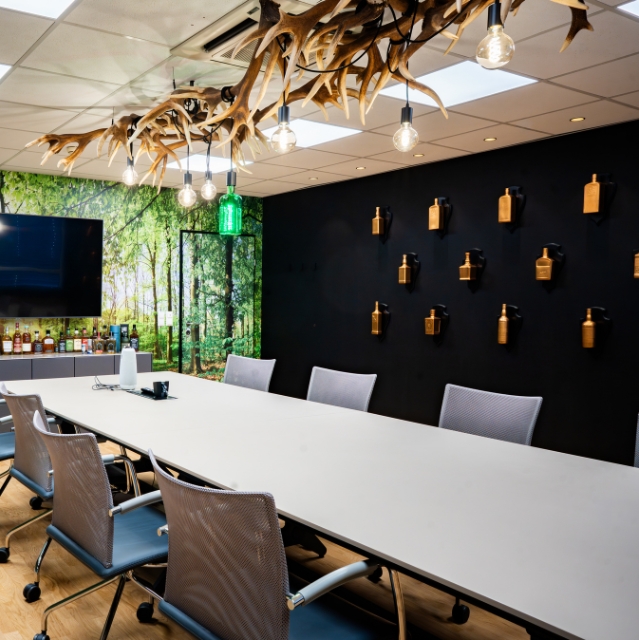 Meeting Room with a close-up of a rustic ceiling lamp made of intertwined antlers with exposed light bulbs in a modern meeting room.